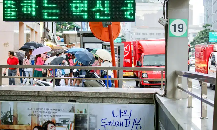 우산을 쓴 사람들이 서 있는 버스 정류장